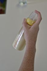 Someone shaking a bottle to mix the infant formula