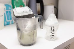 image of breastmilk standing in a container with warm water to heat it up 